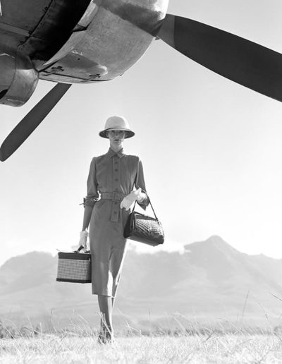 Norman Parkinson, „ART OF TRAVEL“ – DAS BRITISCHE MODEL WENDA PARKINSON TRÄGT EIN GRAUES GABARDINE-KLEID VON DORVILLE AM GEORGE AIRFIELD IN NAIROBI, KENIA, SÜDAFRIKA, NEBEN EINEM HERMES-FLUGZEUG FÜR DIE BRITISH VOGUE, MAI 1951. Galerie Stephen Hoffman